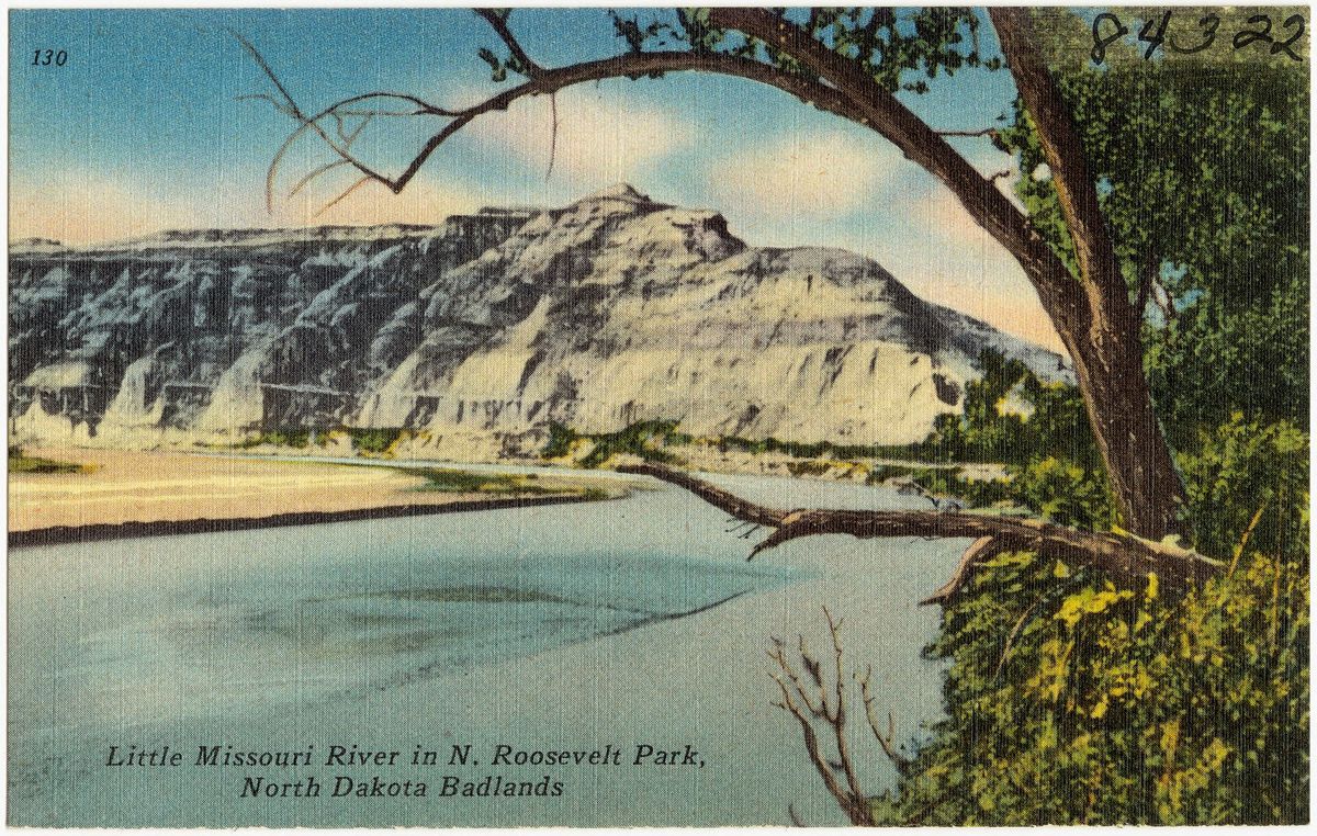 Hand-tinted postcard of the Little Missouri River below a pale butte, framed by a cottonwood branch
